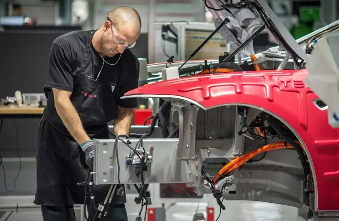 Technician working on a Tesla battery compartment