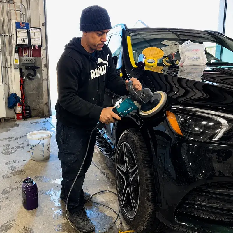 Technician refinishing a Mercedes-Benz at Fireplace Auto Collision