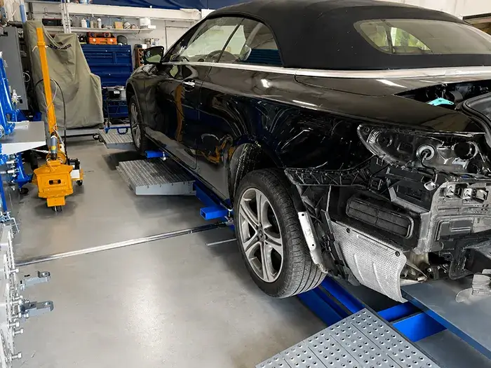 Vehicle secured on a Car-O-Liner frame repair system during collision repair at Fireplace Auto Collision.