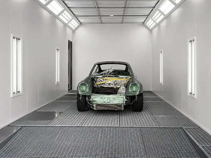 Classic Porsche prepared for automotive refinishing inside the paint booth at Fireplace Auto Collision.